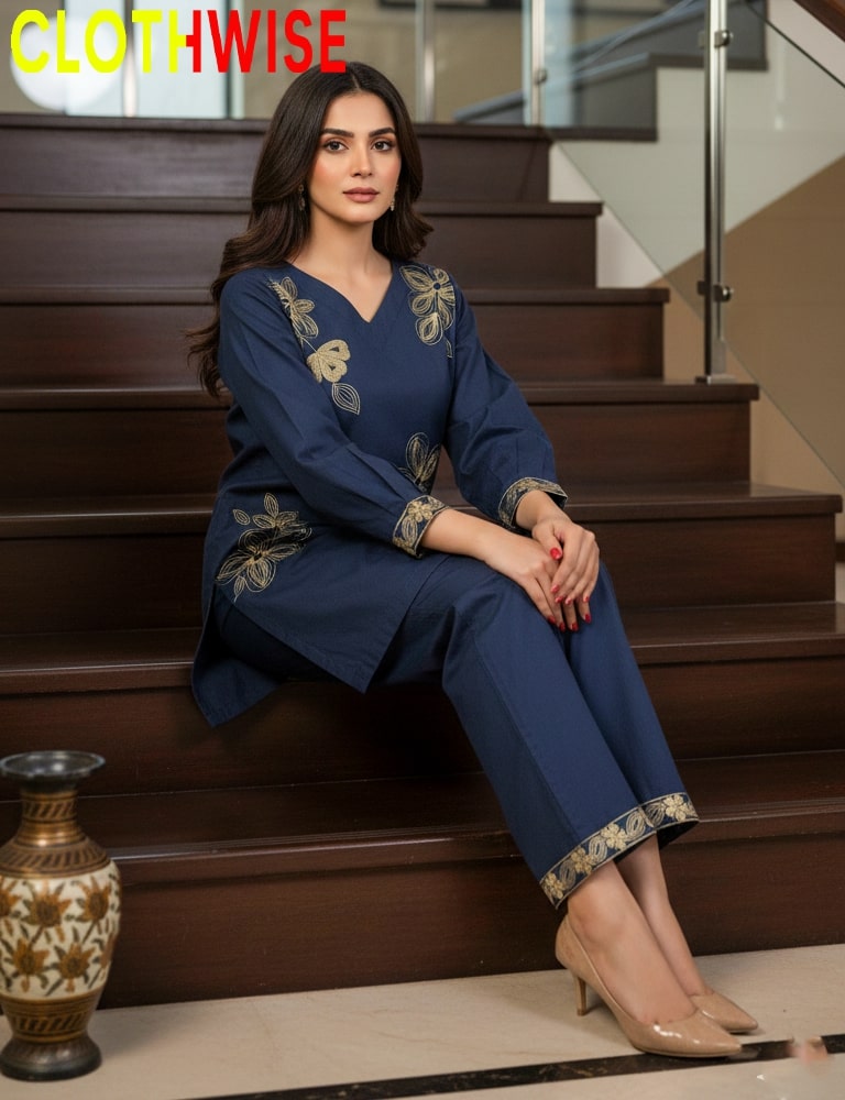 Woman in a blue outfit with gold embroidery sitting on stairs, brand 'CLOTHWISE' visible