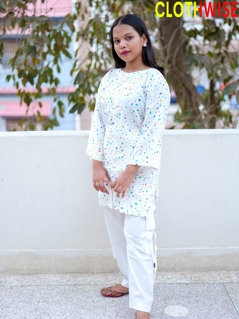 Person wearing a white outfit with colorful patterns outdoors.