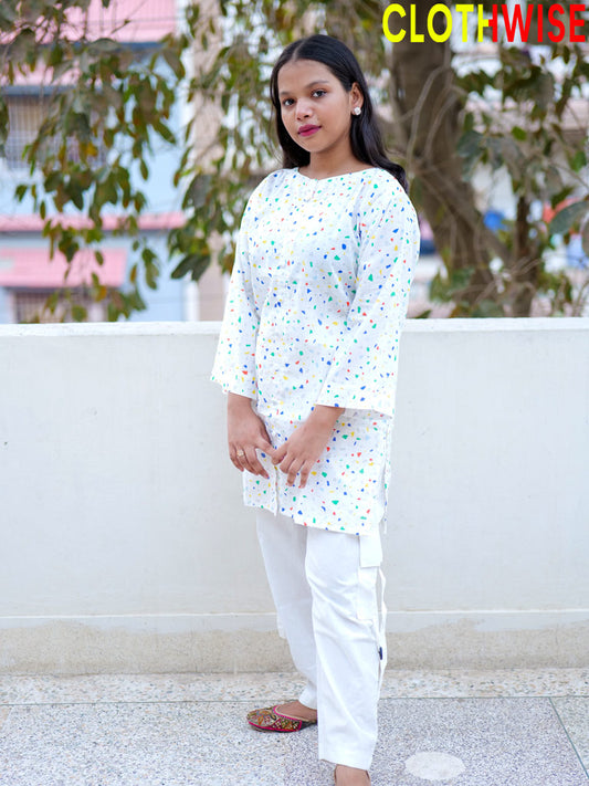 Person wearing a white outfit with colorful patterns outdoors.