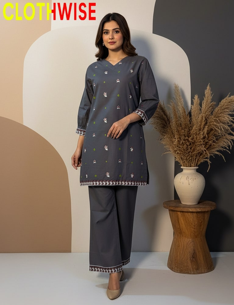 Woman wearing a gray outfit with a 'ClothWise' label, standing next to a decorative vase and plant.