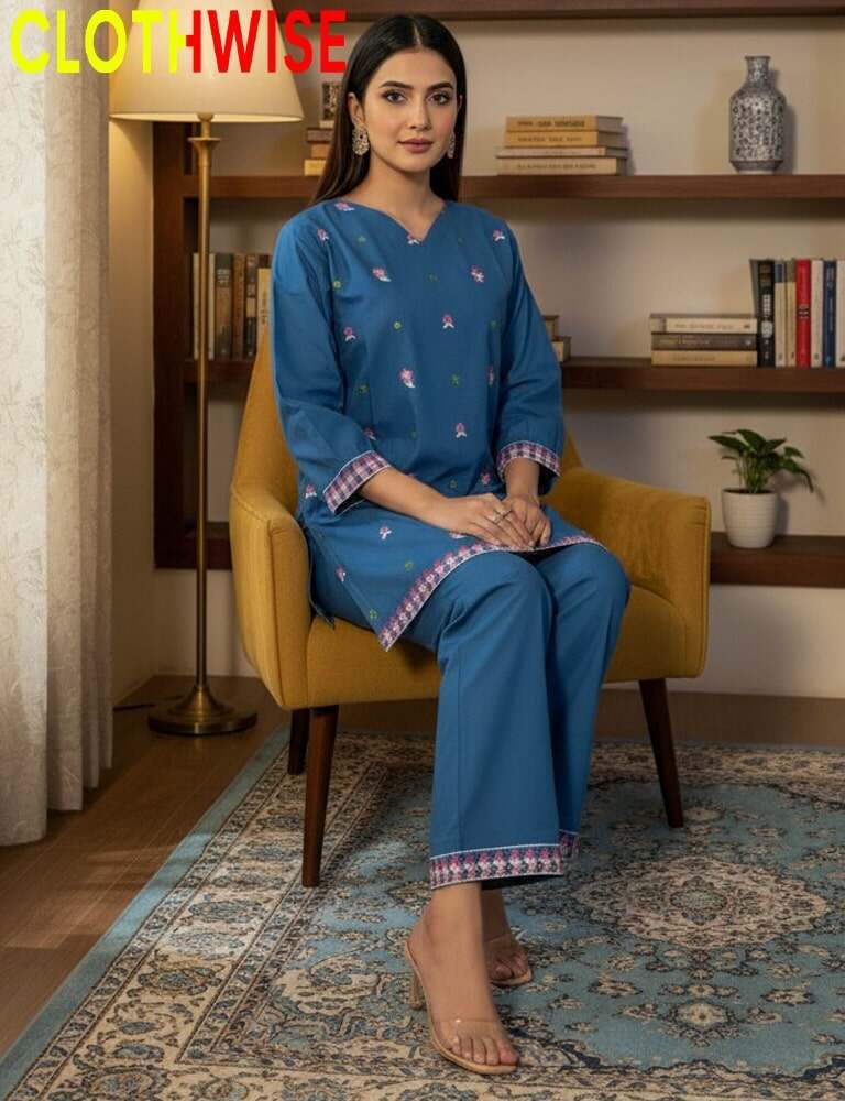 Woman in a blue outfit sitting on a yellow chair in a room with a shelf and plant.