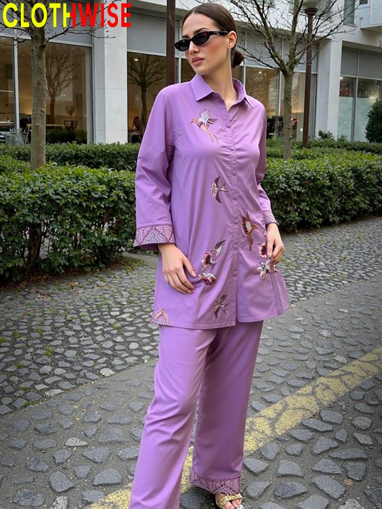 Woman wearing a purple outfit with floral embroidery on a stone path.