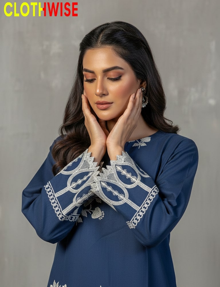 Woman wearing a blue dress with white embroidery against a gray background, branded 'CLOTHWISE'.