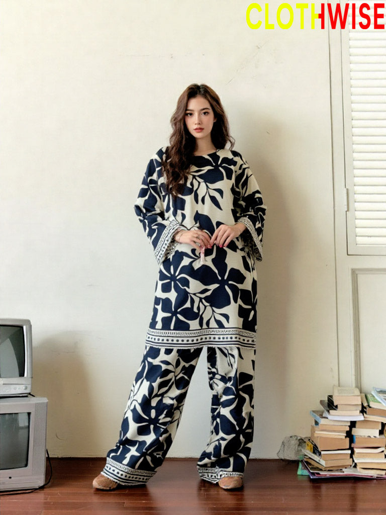 Woman wearing a floral patterned outfit standing in a room with books and a television.