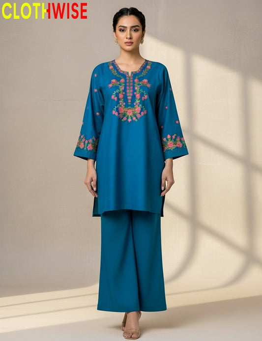 Woman wearing a blue embroidered outfit with 'CLOTHWISE' branding.