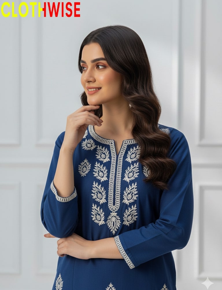 Woman wearing a blue embroidered dress with a white background, featuring the brand 'Clothwise'.