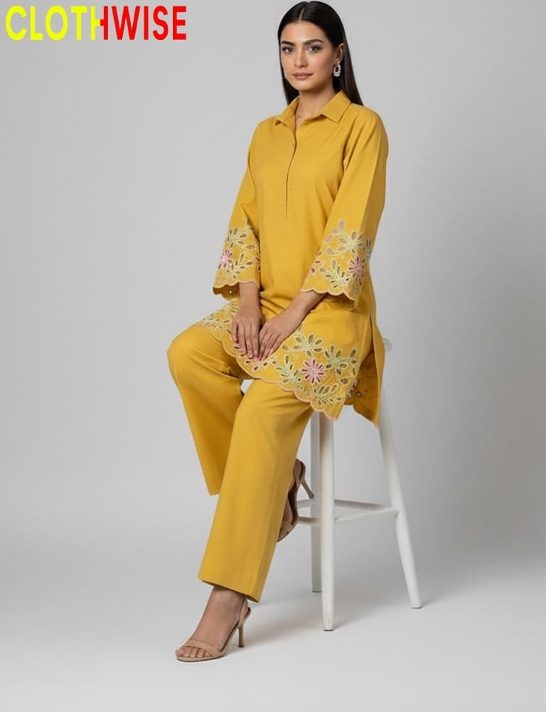 Woman wearing a yellow outfit with floral embroidery sitting on a white stool against a gray background, with 'CLOTHWISE' branding.