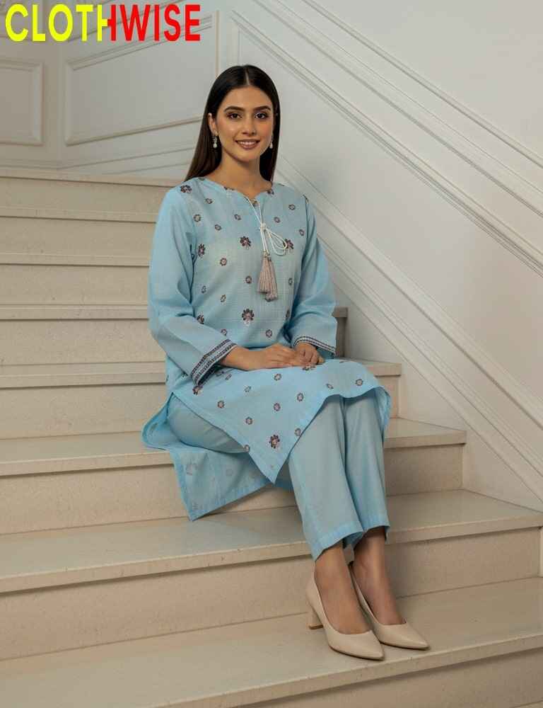 Woman in a light blue traditional outfit sitting on stairs with 'CLOTHWISE' branding.