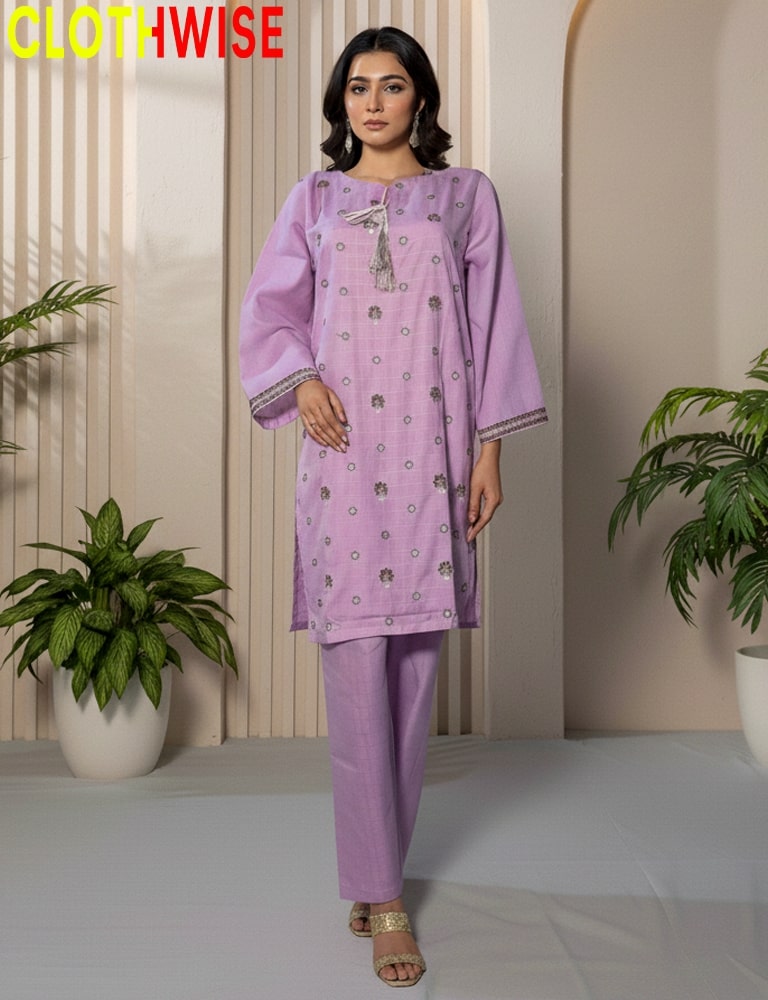 Woman wearing a purple outfit with floral patterns in a minimalistic setting with plants.