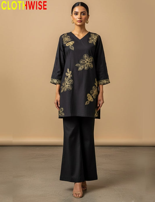 Woman wearing a black outfit with gold embroidery against a beige background, branded 'Clothwise'.