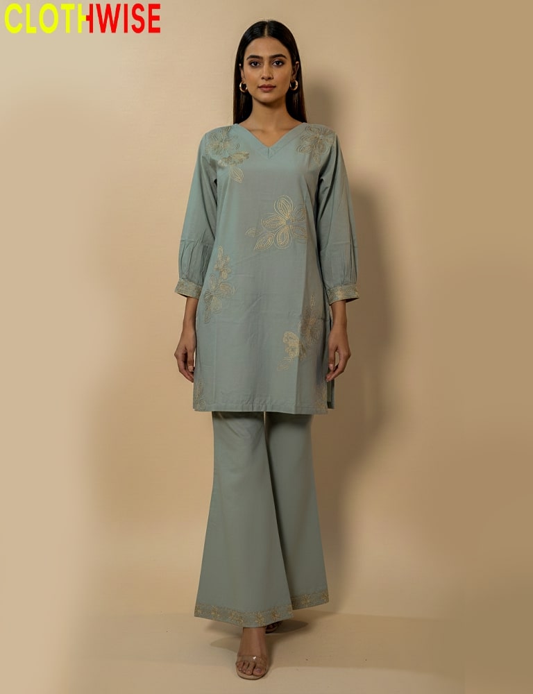 Woman wearing a light blue embroidered outfit with wide-leg pants on a beige background, branded 'Clothwise'.