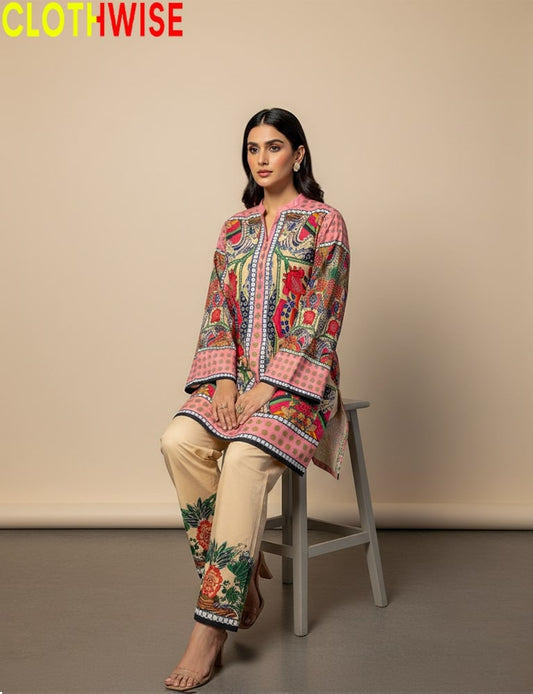Woman wearing a colorful embroidered outfit sitting on a stool with 'CLOTHWISE' branding.