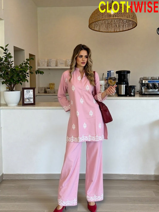 Woman in a pink outfit standing in a kitchen with 'ClothWise' branding.