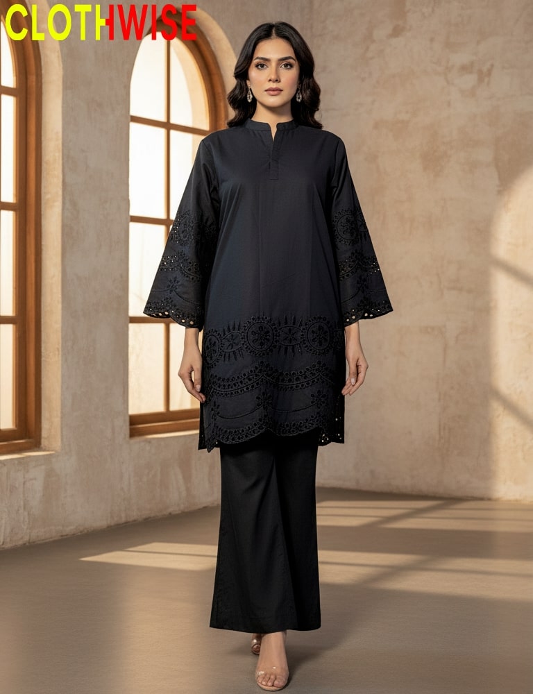 Woman wearing a black outfit with intricate designs in a room with arched windows.