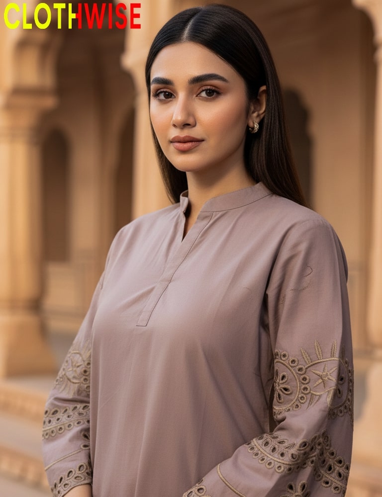 Woman wearing a light brown outfit with lace details, standing in front of an architectural background.