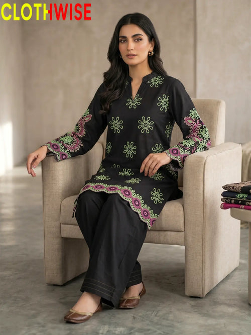 Woman sitting on a chair wearing a black embroidered outfit with 'CLOTHWISE' branding.