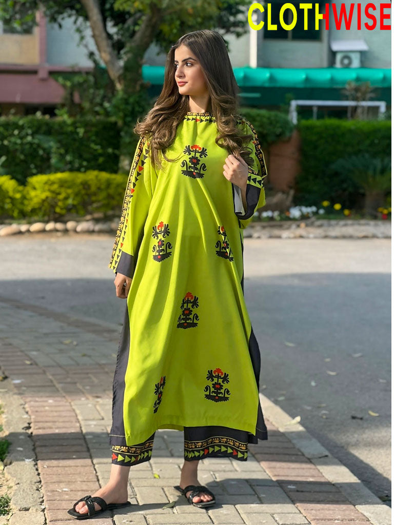 Woman wearing a bright green dress with black patterns on a street.