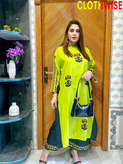 Woman in a bright green traditional outfit with floral patterns standing indoors.