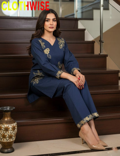 Woman in a blue outfit with gold embroidery sitting on stairs, brand 'CLOTHWISE' visible