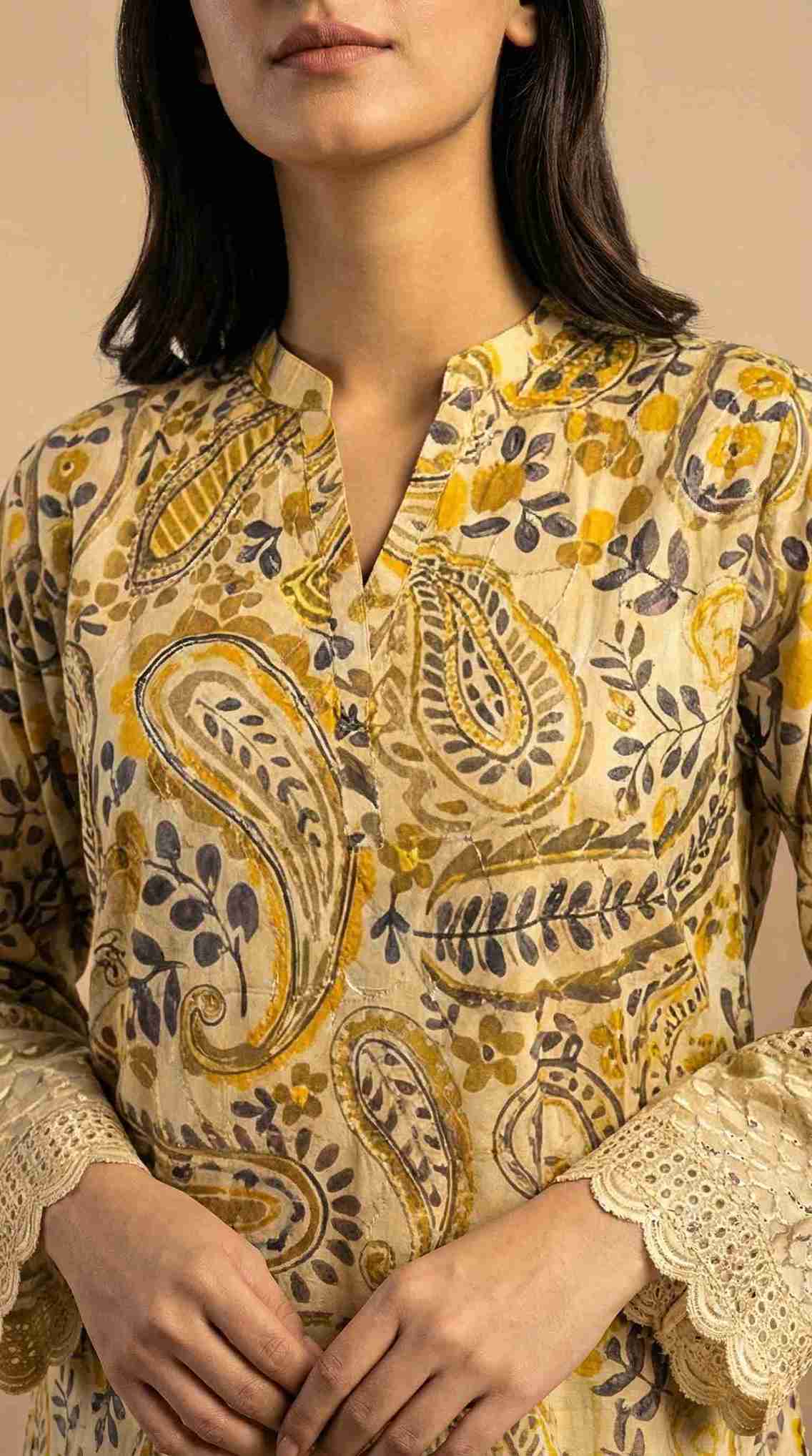 Woman wearing a patterned top with lace details on a beige background