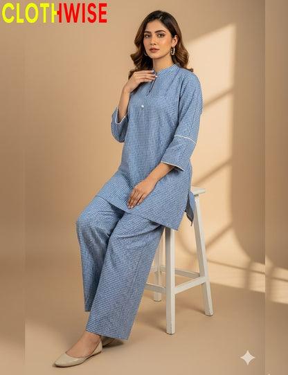 Woman wearing a blue checkered outfit on a beige background with 'CLOTHWISE' branding.