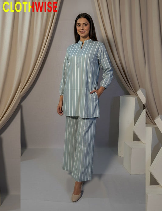 Woman wearing a striped outfit standing in front of beige curtains with 'CLOTHWISE' branding.