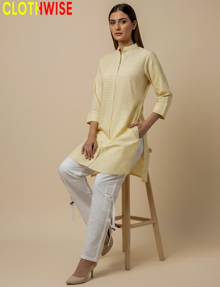 Woman wearing a yellow checkered kurta with white pants on a beige background, branded 'CLOTHWISE'.
