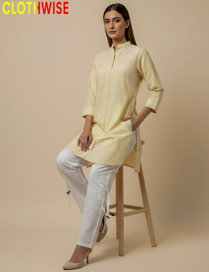 Woman wearing a yellow checkered kurta with white pants on a beige background, branded 'CLOTHWISE'.