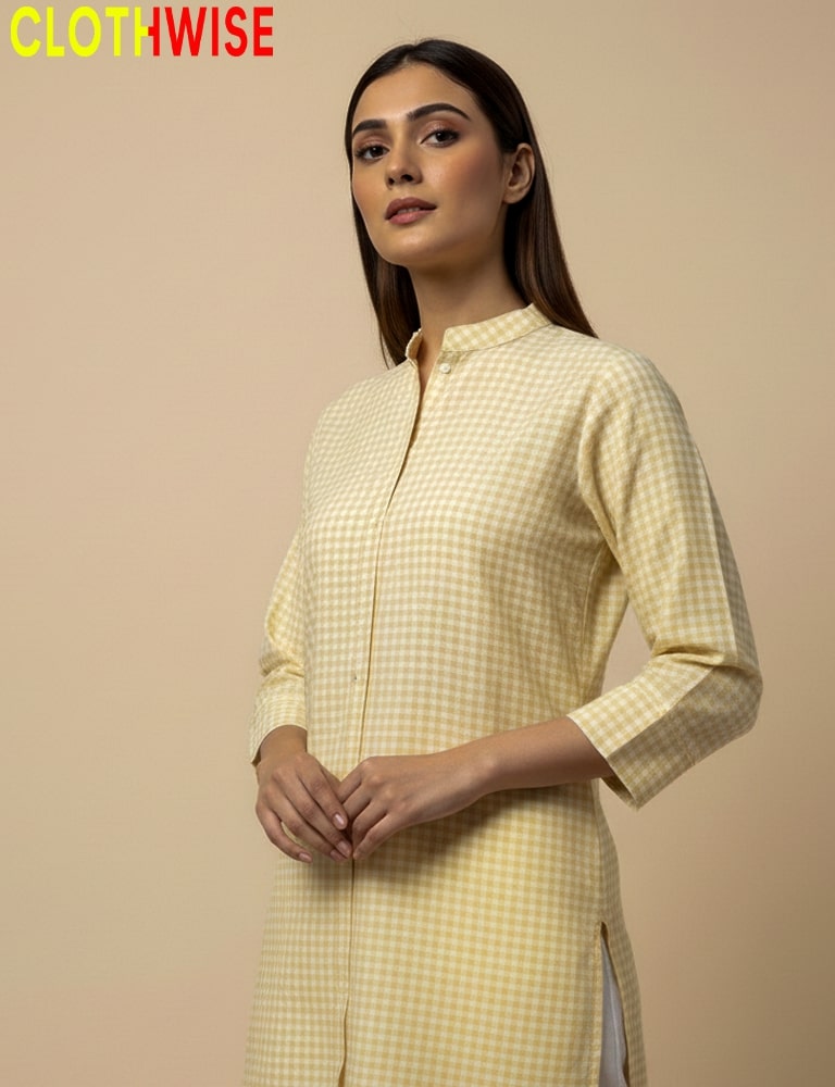 Woman wearing a yellow checkered kurta with a beige background, branded 'CLOTHWISE'.