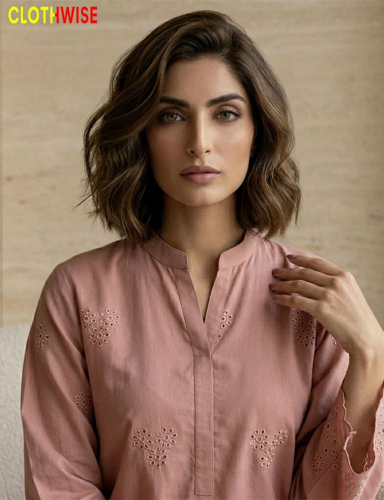 Woman wearing a pink embroidered top with 'CLOTHWISE' branding.