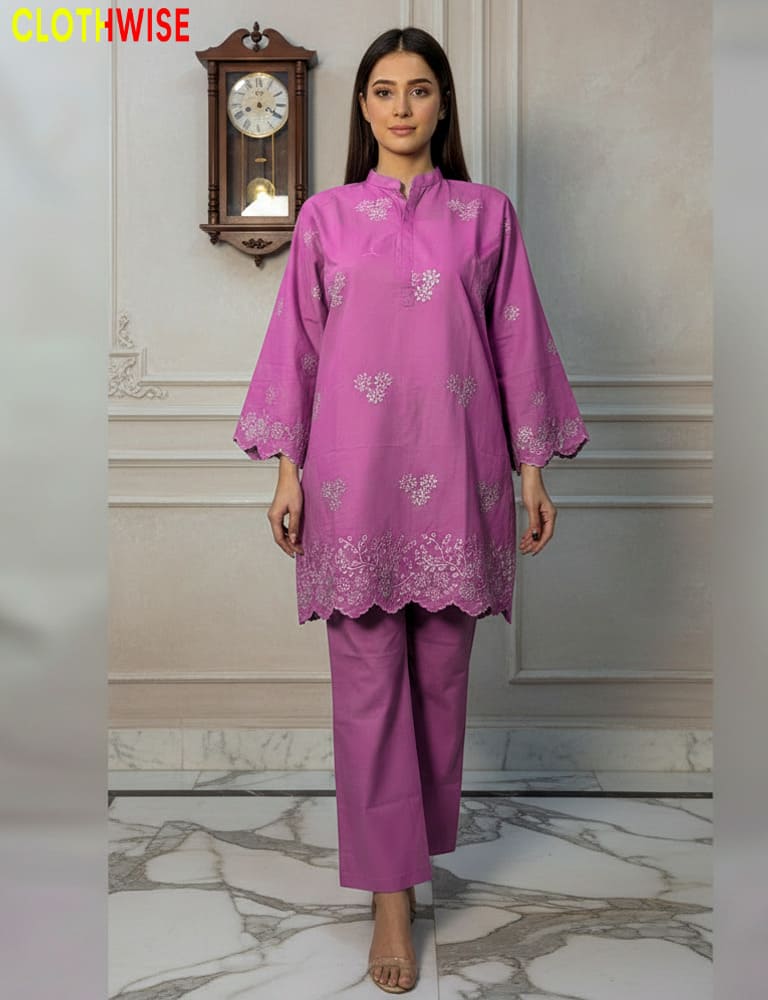 Woman wearing a pink traditional outfit with floral patterns in a decorative room.
