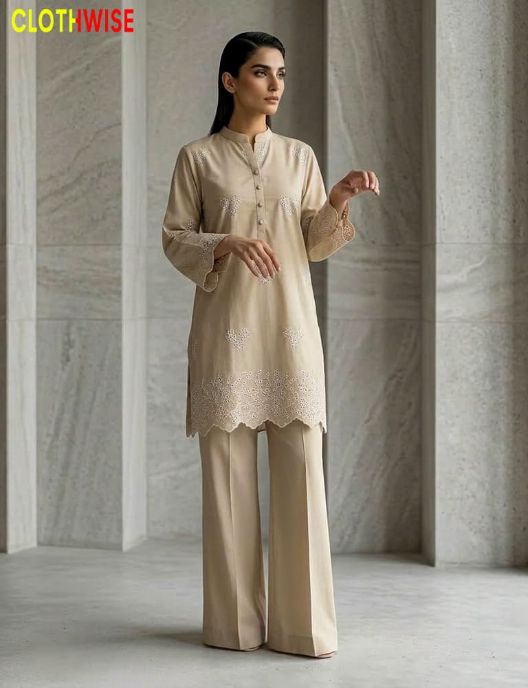 Woman wearing a beige outfit with lace details in a minimalistic setting.