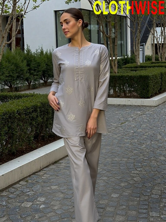 Woman wearing a gray outfit with floral patterns in an outdoor setting, branded 'ClothWise'.