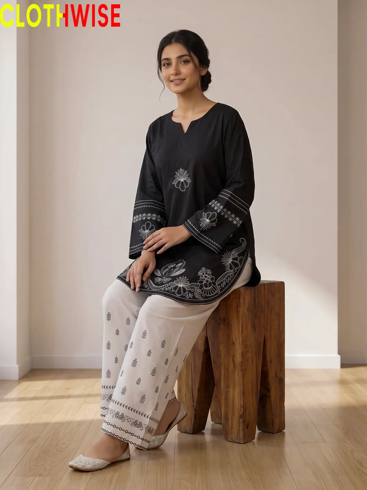 Petal black embroidered suit - sitting view showing flared bottom
