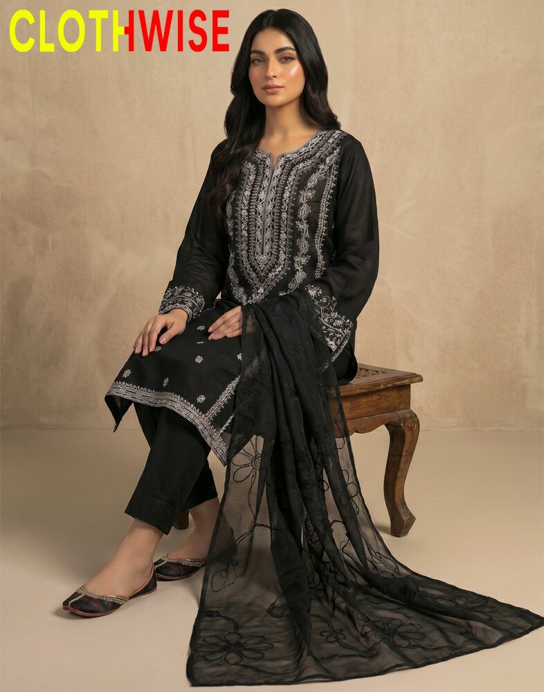 Woman wearing a black embroidered outfit with a sheer dupatta, sitting on a wooden stool against a beige background. Brand 'CLOTHWISE' visible.