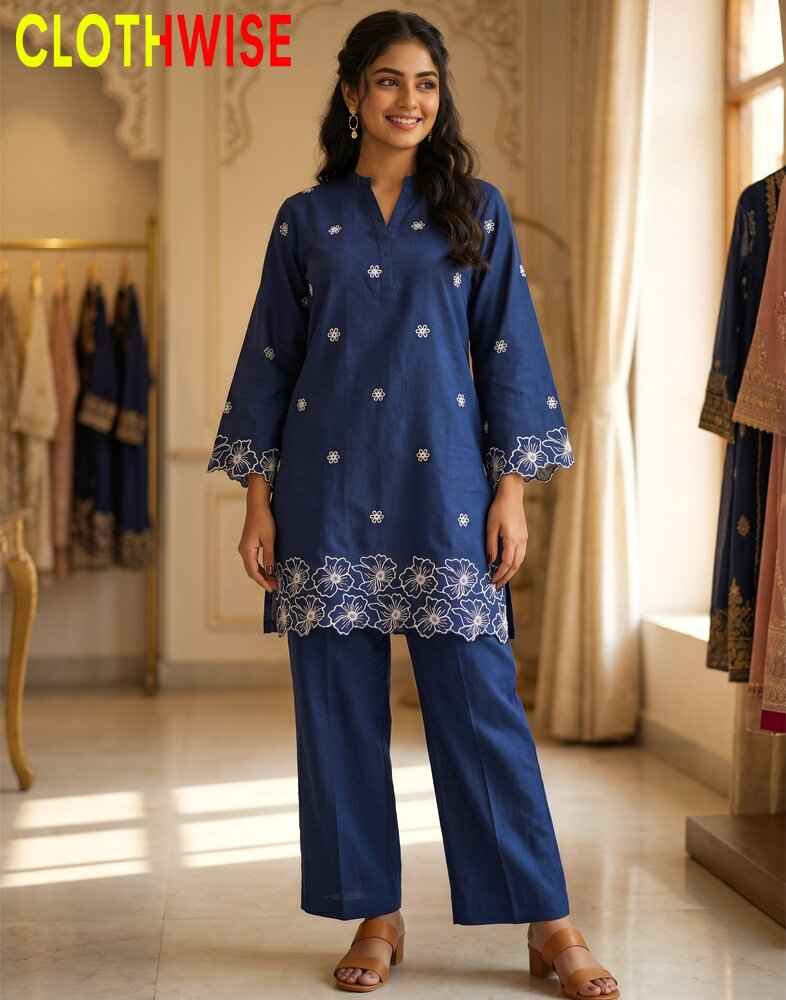 Woman wearing a blue embroidered outfit in a clothing store.