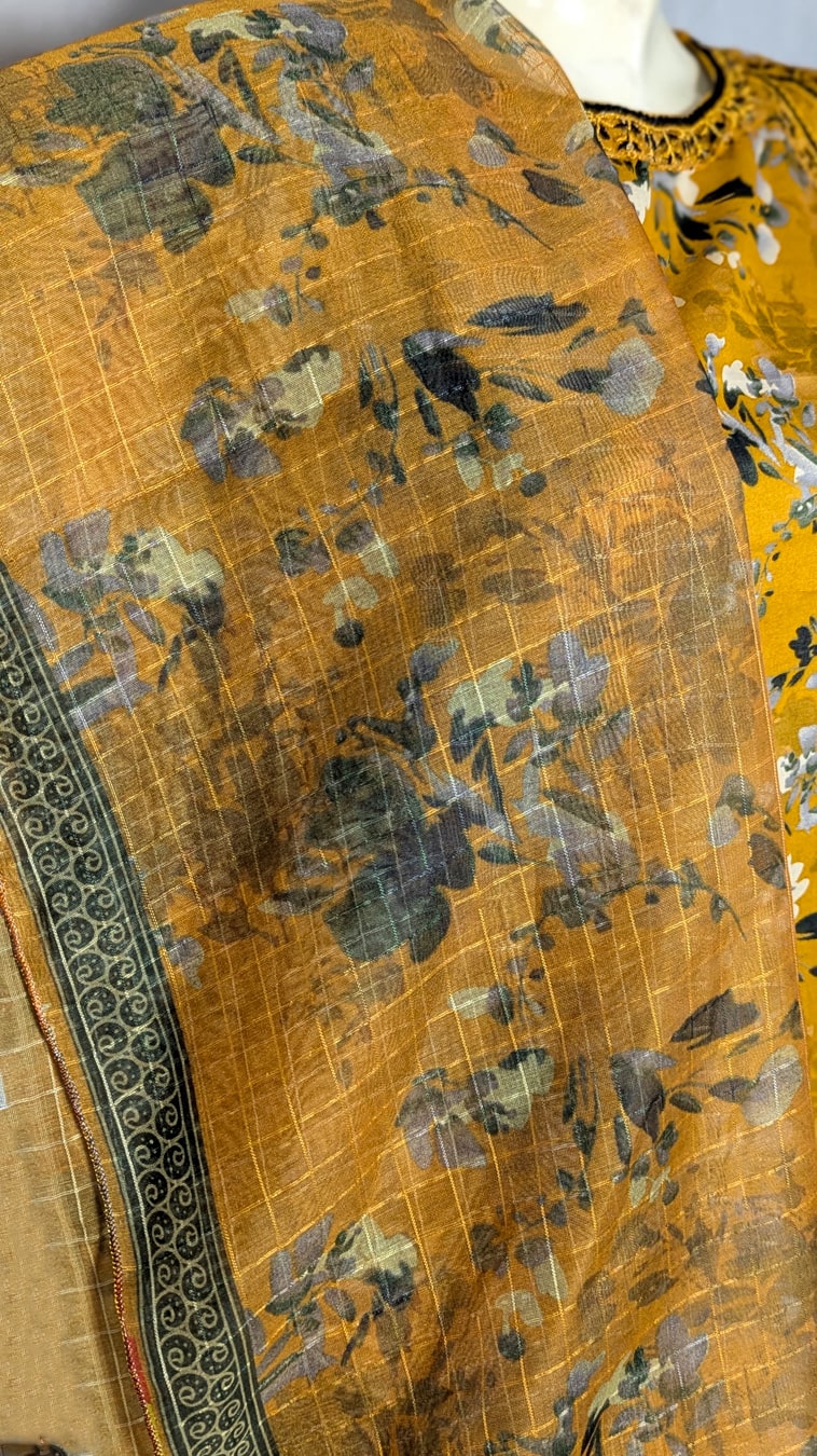 Close-up of a patterned fabric with yellow background and black floral design