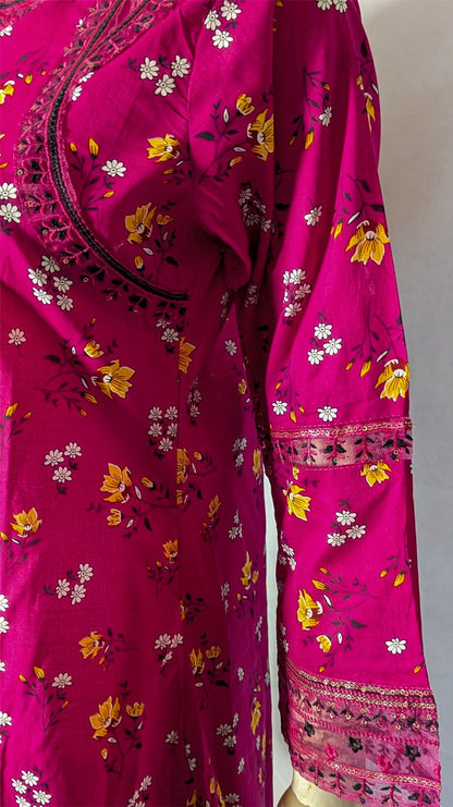 Pink traditional outfit with floral patterns on a mannequin against a plain background