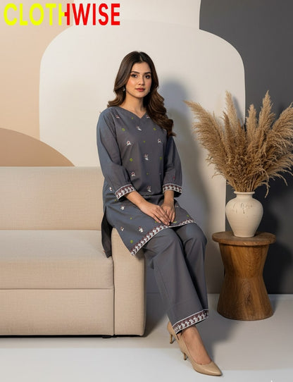 Woman in a gray outfit sitting on a beige sofa with a decorative vase and plant in the background, branded 'CLOTHWISE'.