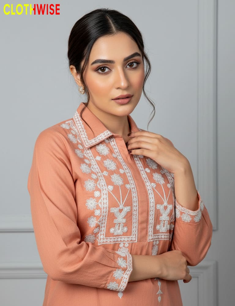 Woman wearing a peach-colored embroidered shirt with a gray background, featuring the 'Clothwise' brand.