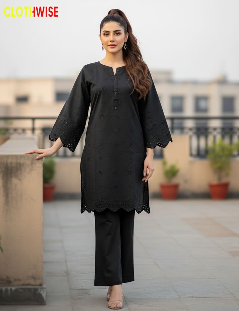 Woman wearing a black kurta with lace details on a rooftop.