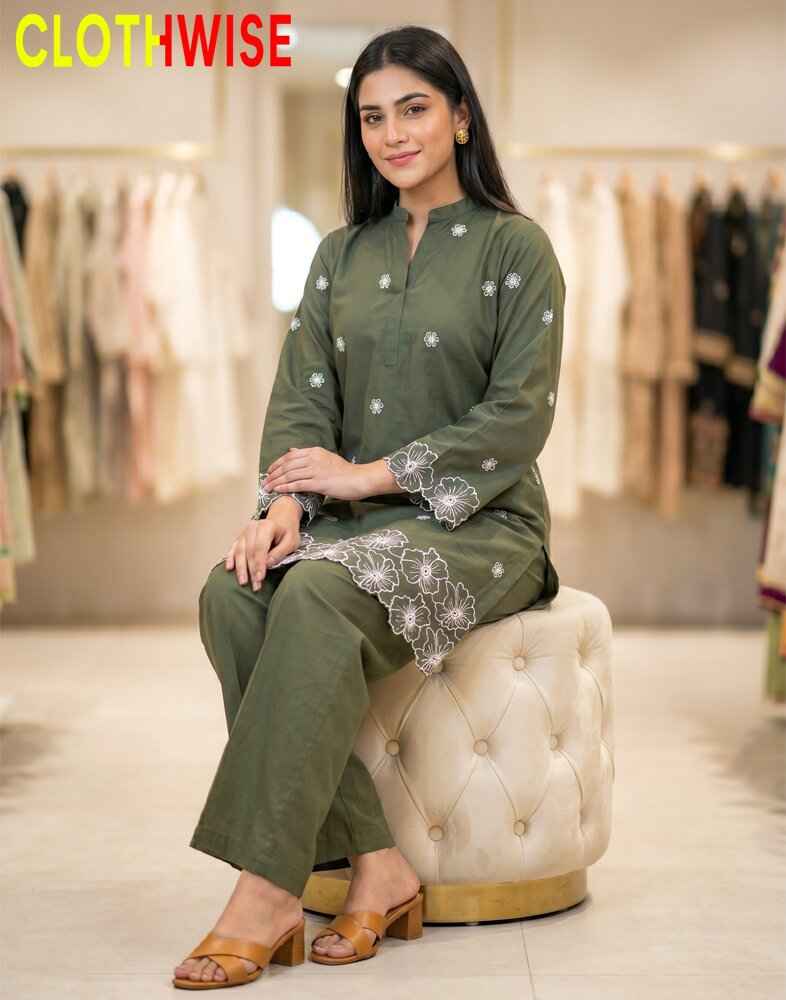 Woman in a green traditional outfit sitting on a stool with 'Clothwise' branding.