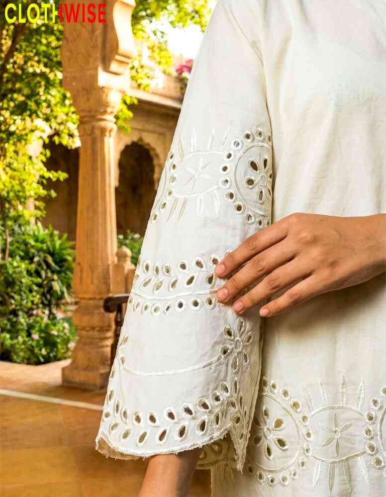 White embroidered dress with a blurred outdoor background