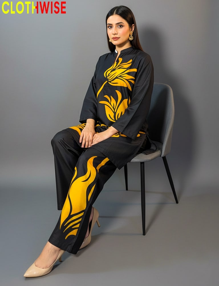 Woman sitting on a chair wearing a black outfit with yellow floral patterns, branded 'CLOTHWISE'.