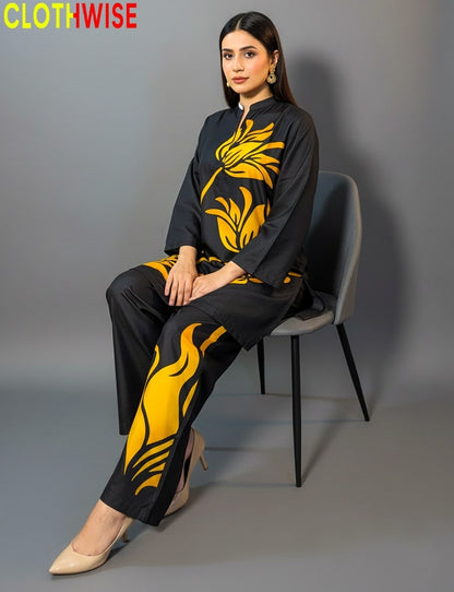 Woman sitting on a chair wearing a black outfit with yellow floral patterns, branded 'CLOTHWISE'.