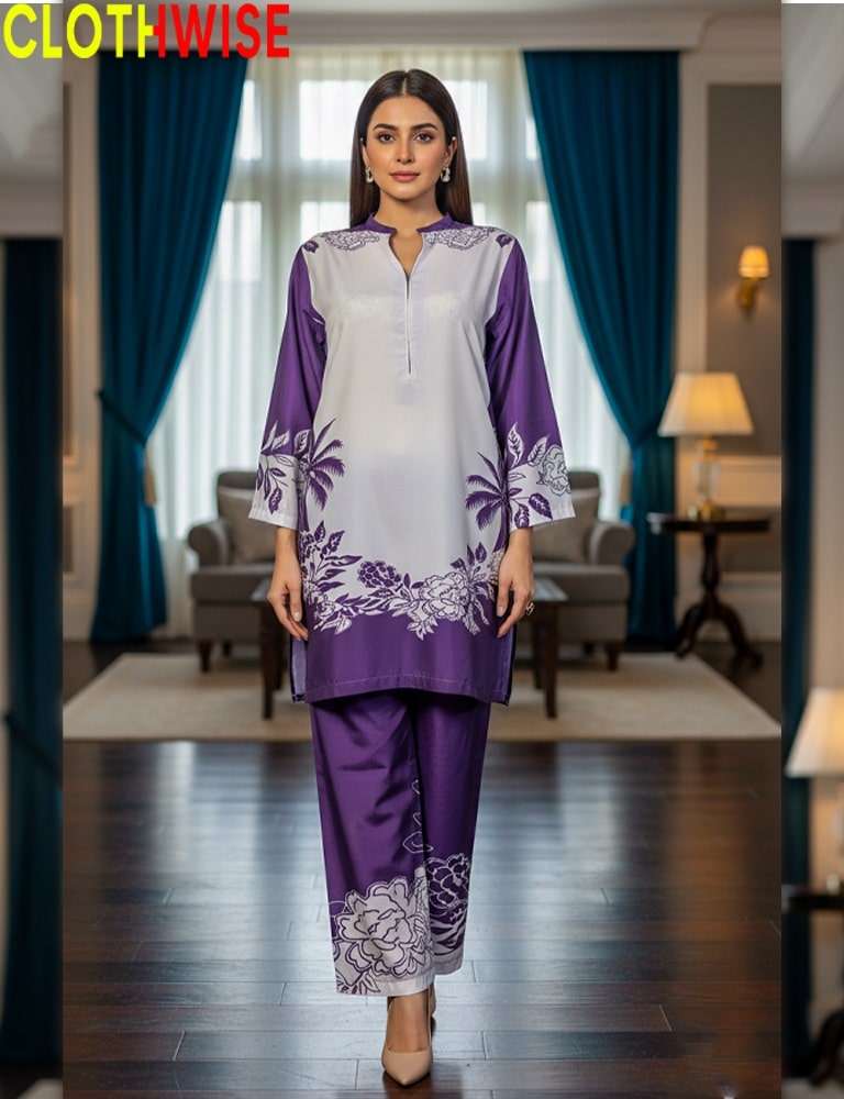 Woman wearing a purple and white outfit with floral patterns in a room with blue curtains.