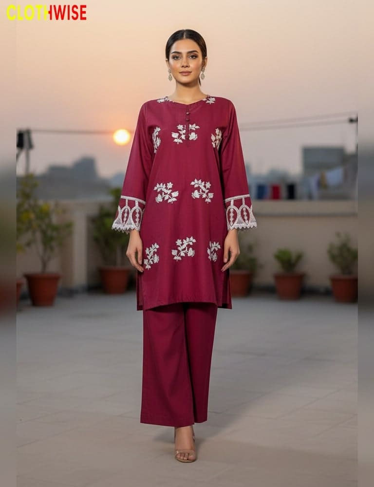 Woman wearing a maroon outfit with white embroidery on a rooftop background
