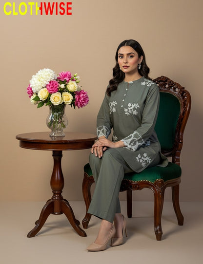 Woman in a green outfit sitting on a chair with a table and flowers in the background, branded 'ClothWise'.