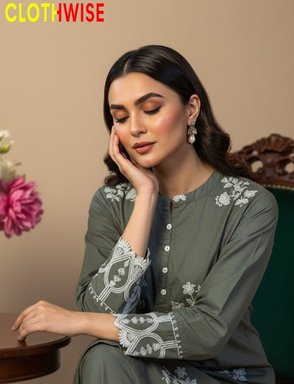 Woman wearing a gray embroidered outfit with a floral background, featuring the brand 'Clothwise'.