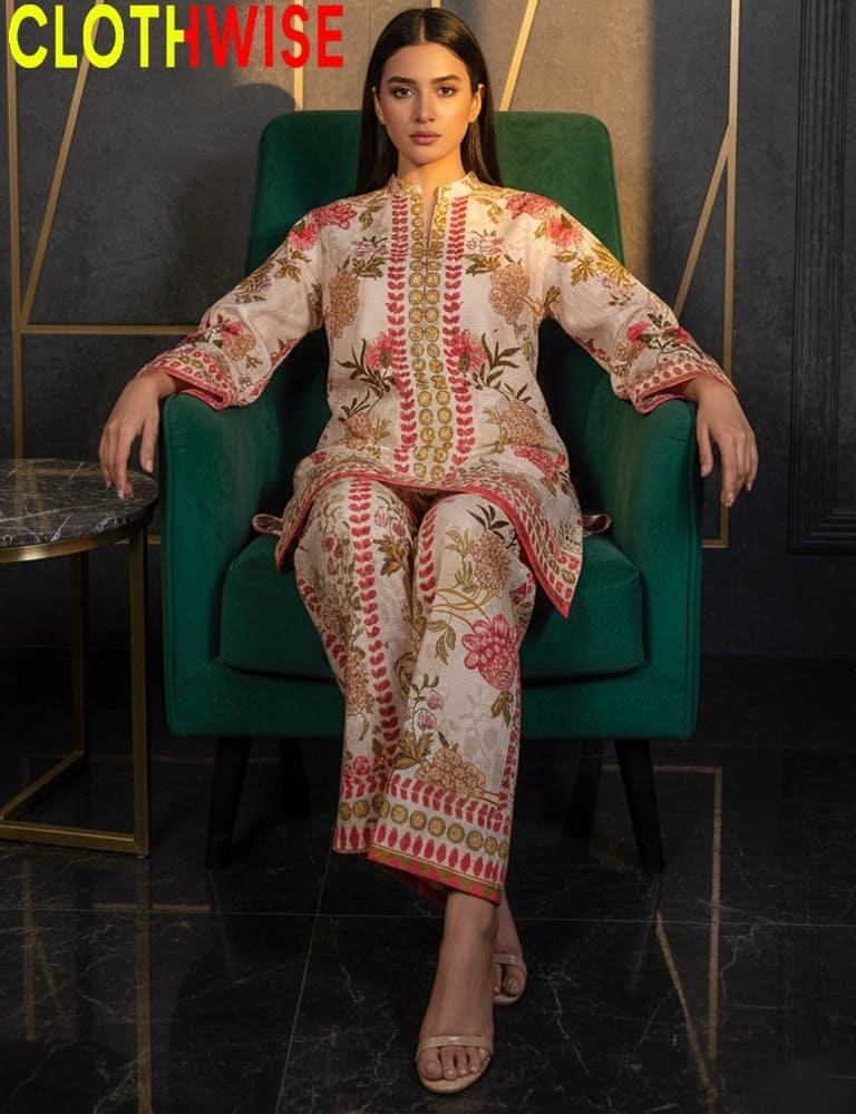 Woman in an embroidered outfit sitting on a green chair with 'CLOTHWISE' branding.